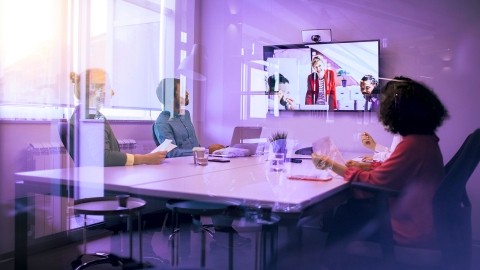 Image of people in an online meeting inside a glass room